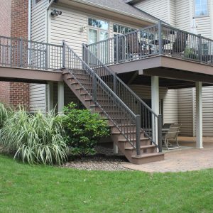 stairs to the underneath of a vinyl deck with an outdoors deck below it